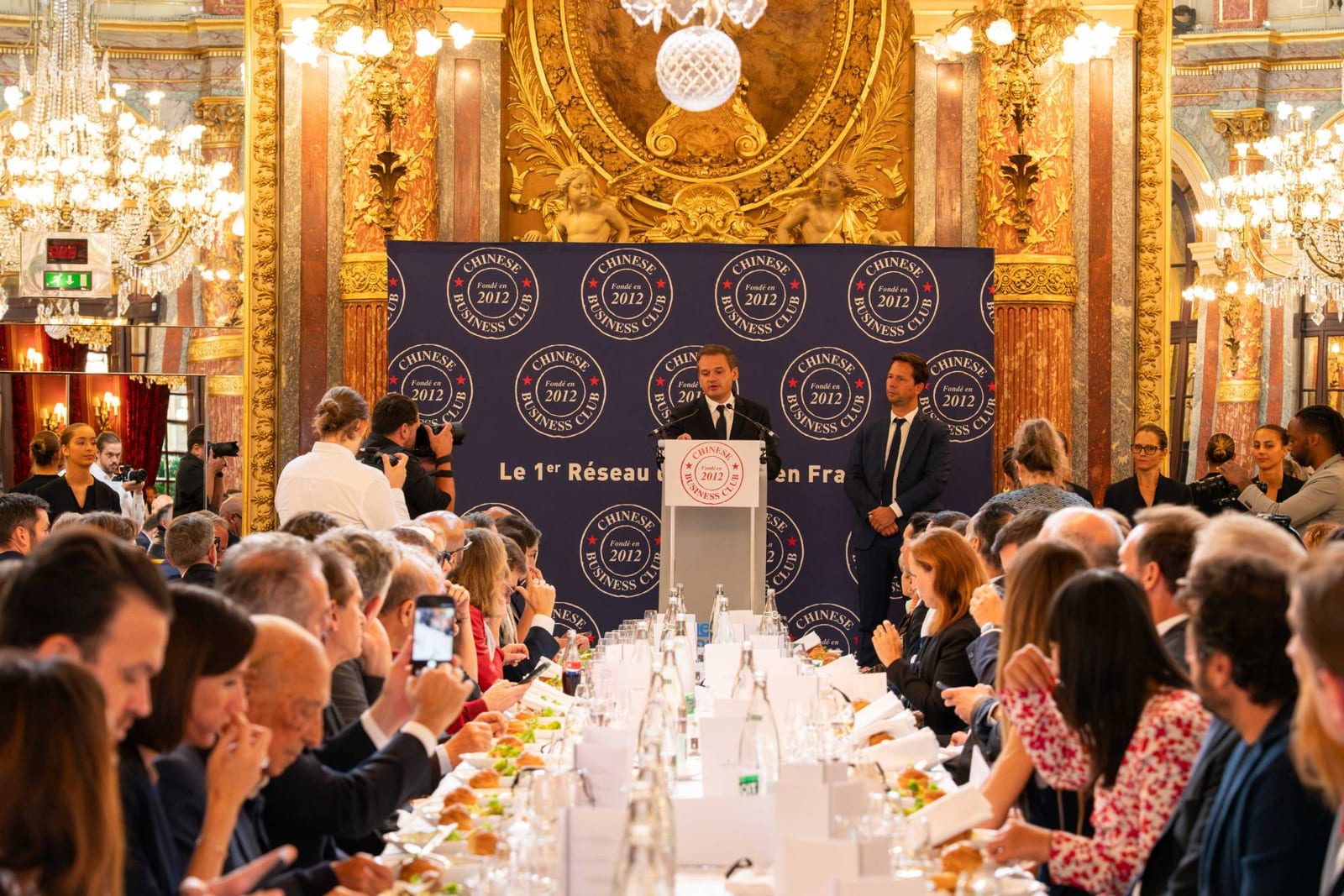 Une prise de parole au pupitre devant les convives du déjeuner du Chinese Business Club, dans le salon Opéra de l’InterContinental Paris
