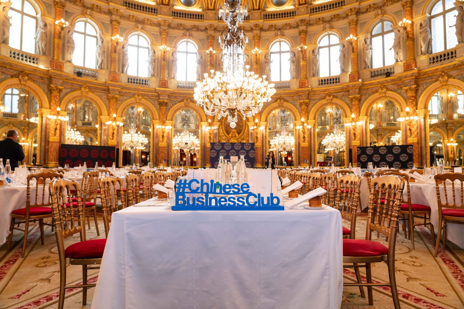 Une table dressée dans le salon Opéra de l’InterContinental Paris, avec le sigle #ChineseBusinessClub en lettres bleues